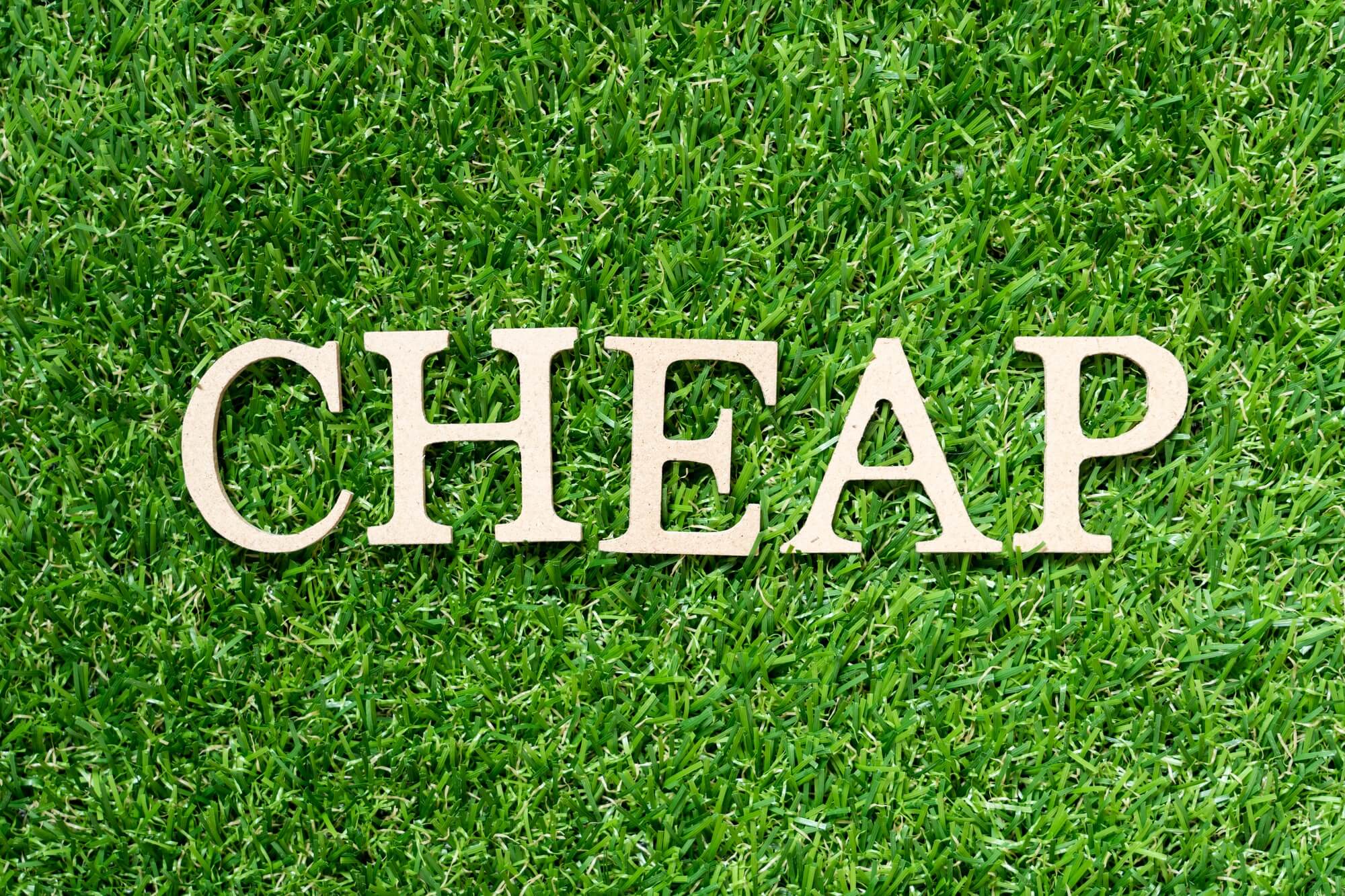 Wood alphabet letter in word cheap on artificial green grass background